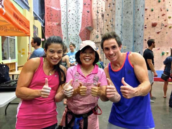 Hoang Taing giving two thumbs up at the rock climbing wall